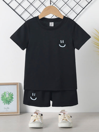 2 peças Jogo de camisa de manga curta e short estampado de cor sólida casual para meninos jovens com estampa de rosto sorridente, adequado para o verão, lazer, festas, uso diário, escola, viagens, encontros