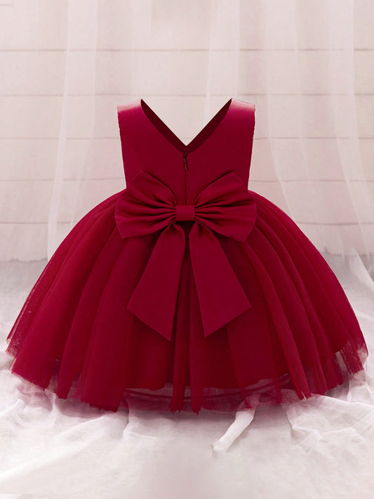 Vestido bebê menina decote V sem mangas em cor sólida com laço nas costas, adequado para festas.